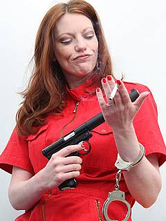 Sexy redhead had just escaped from prison: still handcuffed, smoking and holding a gun in her hands