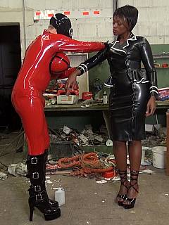 Male slave is dressed up as latex fuck-doll, wearing gas mask and serving beautiful ebony dominatrix