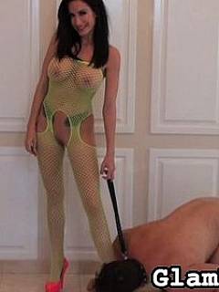 Erotic mistress in yellow fishnet body-suit is having a stroll with leashed petboy