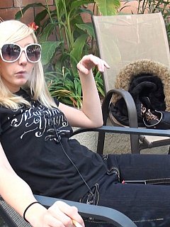 Mistress is enjoying two things: a cigarette in her mouth and a slave kissine ger feet at the very same time
